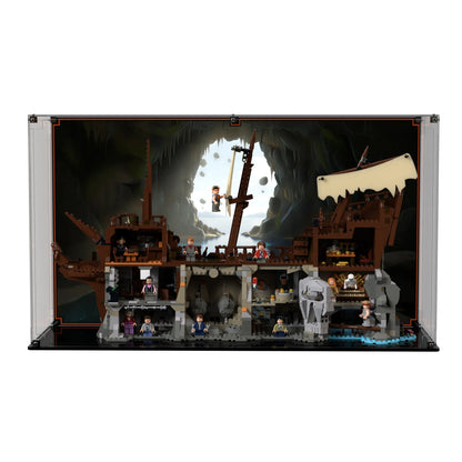 Brick In It premium acrylic display case for LEGO Ideas The Goonies (21363) set, printed coastal-cavern background view facing front.